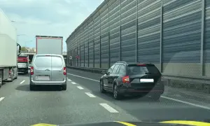 Samochody stoją w korku na autostradzie. Kierowcy czekają na możliwość zjazdu, a jazda na suwak jest jedynym rozwiązaniem.