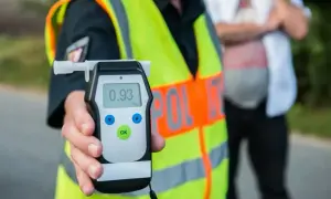 Policjant pokazuje alkomat z wynikiem 0.93. To przypomnienie o **limicie alkoholu w Polsce** i odpowiedzialności za kierowanie po spożyciu.