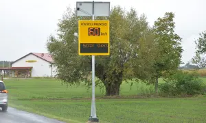 Żółty znak fotoradaru z napisem "Kontrola prędkości", wskazujący 60 km/h i 50 zł opłaty.