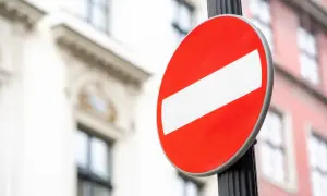 Znak B-18 "zakaz wjazdu" na słupku. Uważaj, bo za ignorowanie tego znaku grozi mandat.