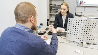 Mężczyzna przekazuje dokumenty do wymiany prawa jazdy urzędniczce.
