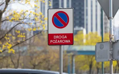 Znak zakazu zatrzymywania się na drodze pożarowej. Upewnij się, że droga jest wolna dla straży pożarnej.