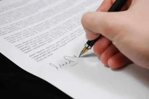 Podpisanie dokumentu, który może dotyczyć dziedziczenia, piórem wiecznym.