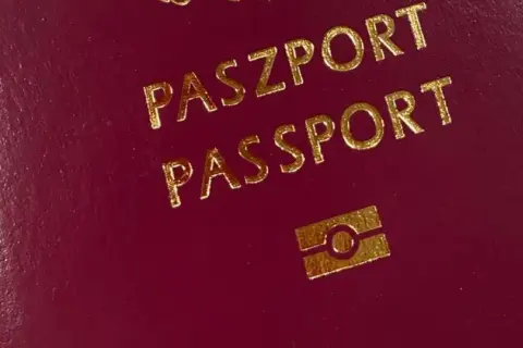 Czerwony paszport z napisem "PASZPORT PASSPORT" i symbolem odcisku palca.