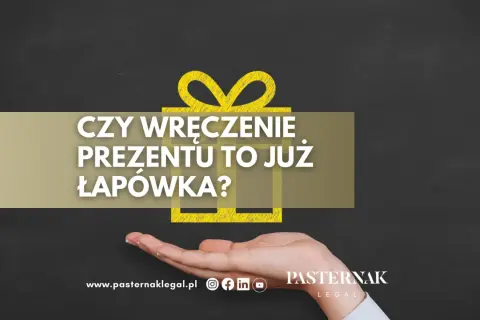 Czy wręczenie prezentu to już łapówka? Dłoń trzyma symbol prezentu, a tekst pyta o granicę między gestem a nielegalnym działaniem.