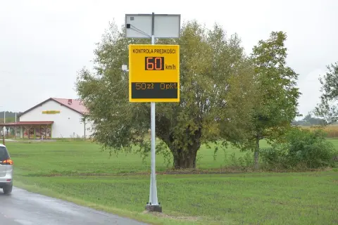 Żółty znak fotoradaru z napisem "Kontrola prędkości", wskazujący 60 km/h i 50 zł opłaty.