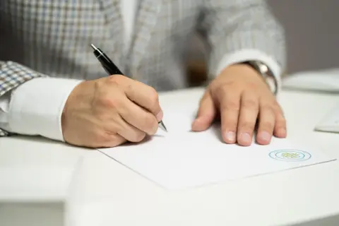 Mężczyzna w eleganckim garniturze składa wniosek o stwierdzenie nabycia spadku.