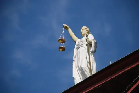Posąg Temidy z wagą i mieczem na tle błękitnego nieba. Symbol sprawiedliwości, 4cmc.