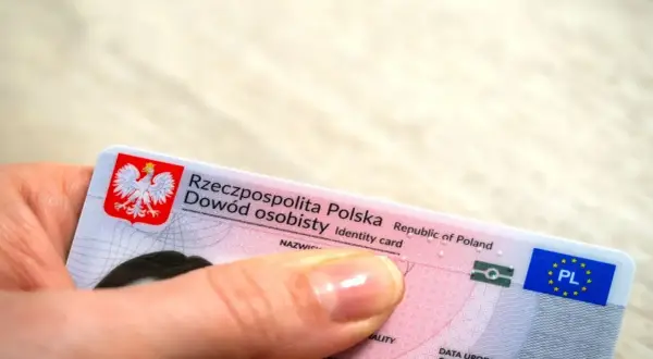 Dłoń trzyma polski dowód osobisty. Zastanawiasz się, ile kosztuje wyrobienie dowodu?