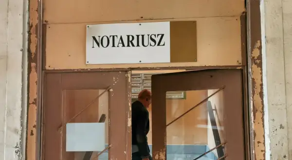 Mężczyzna wchodzi do biura notariusza, gdzie może sporządzić testament.