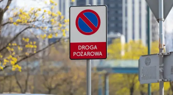 Znak zakazu zatrzymywania się na drodze pożarowej. Upewnij się, że droga jest wolna dla straży pożarnej.