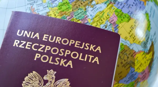 Paszport tymczasowy Rzeczypospolitej Polskiej na tle globusa z zaznaczoną Europą i Bliskim Wschodem.