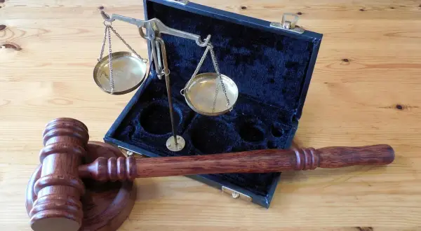 Młotek sędziowski i waga sprawiedliwości w futerale. Symbol prawa i sprawiedliwości, jak w paragrafie 288 kk.