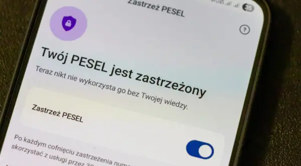 Ekran telefonu z informacją "Twój PESEL jest zastrzeżony" i ikoną tarczy z kłódką.