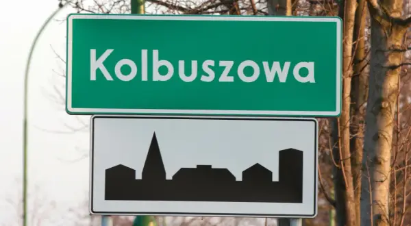 Znak drogowy z napisem "Kolbuszowa" i sylwetką miasta. D42.