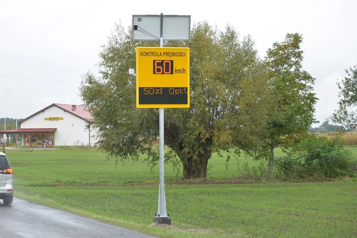 Żółty znak fotoradaru z napisem "Kontrola prędkości", wskazujący 60 km/h i 50 zł opłaty.