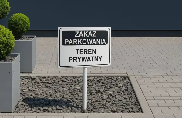 Znak "Zakaz parkowania, teren prywatny" na drodze wewnętrznej. Obok ozdobne krzewy w donicach.
